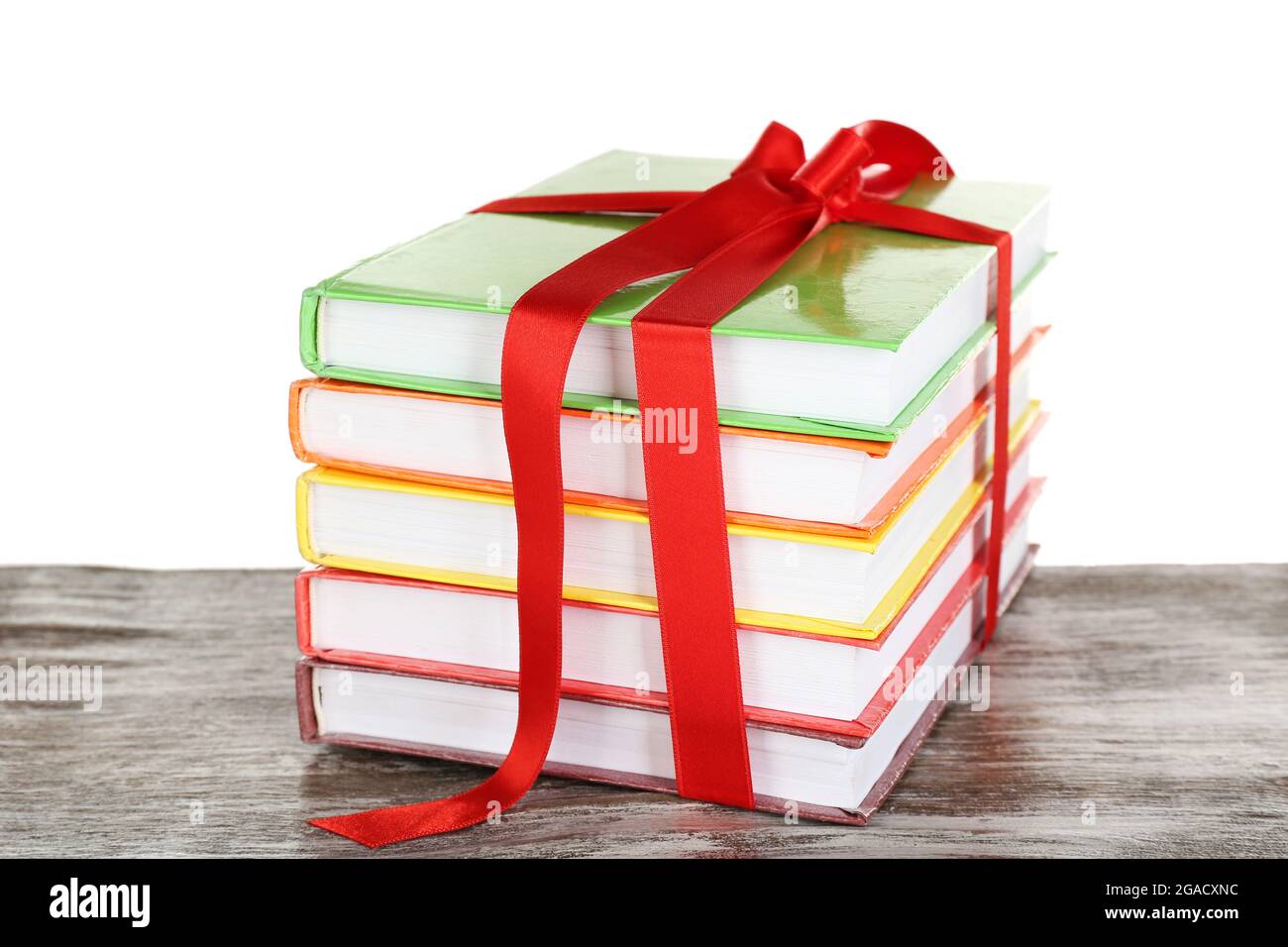 Stack of books with ribbon on light background Stock Photo - Alamy