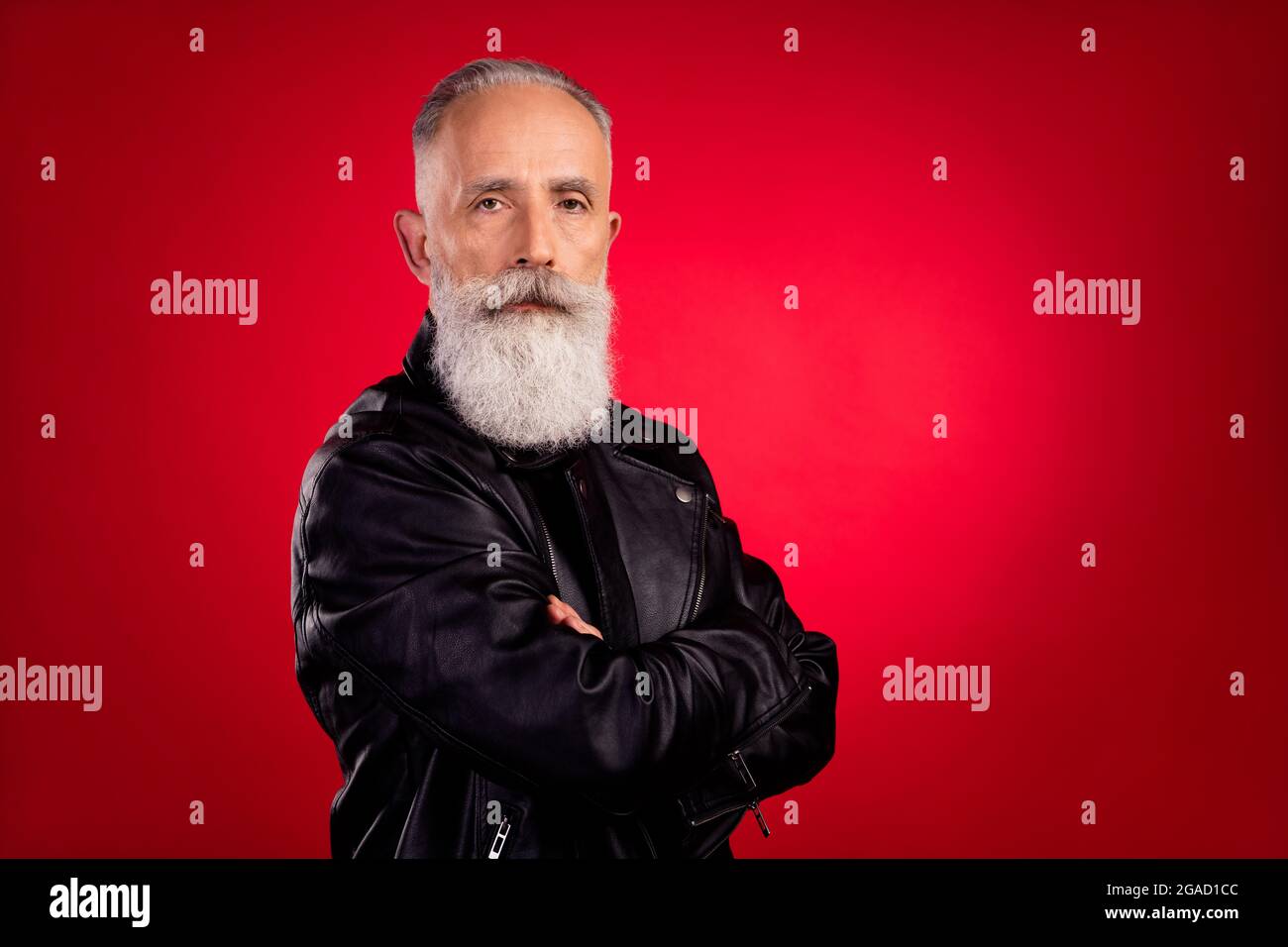 Profile side photo of aged handsome man serious confident crossed hands isolated over red color background Stock Photo
