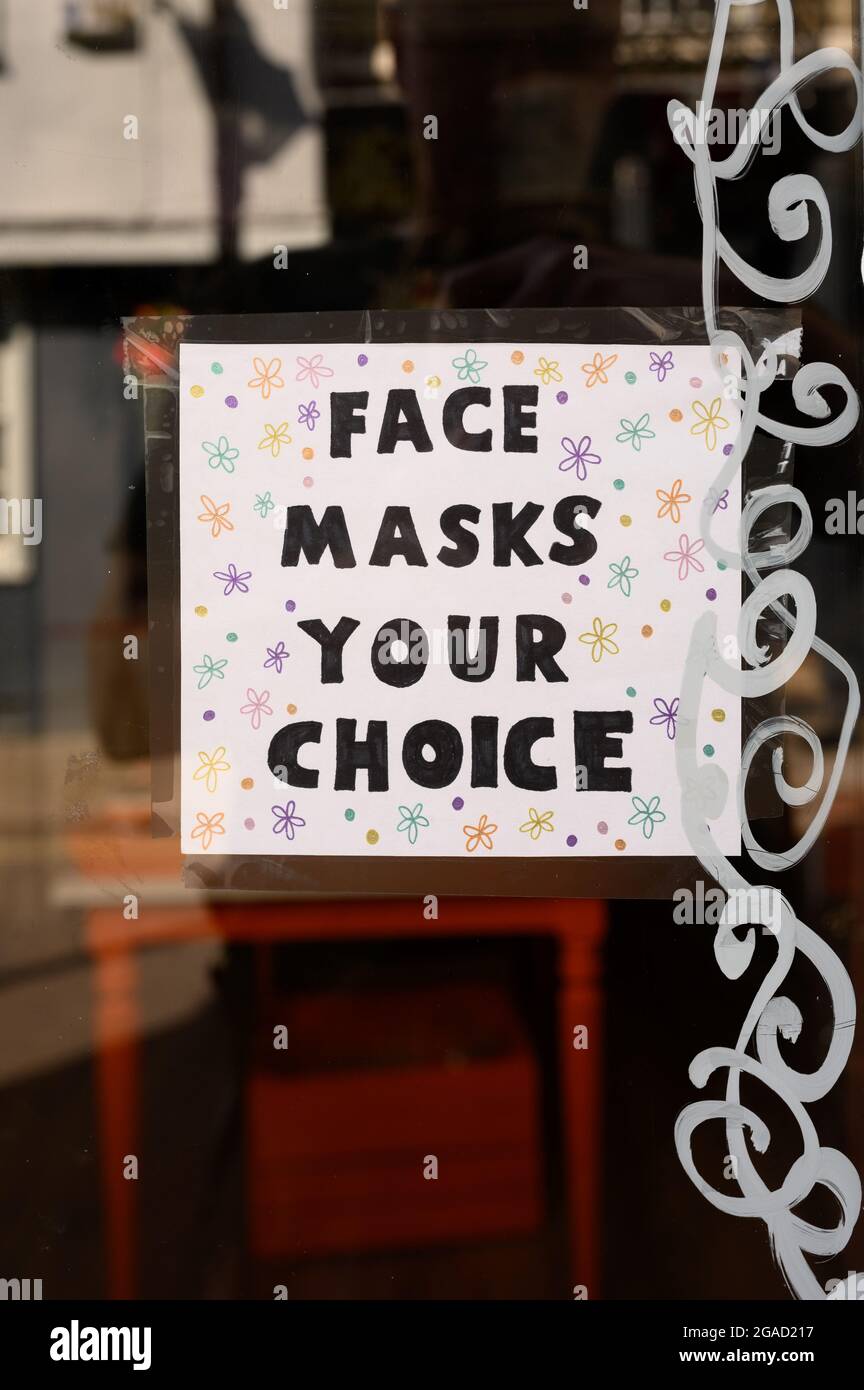 Sign in a shop window saying that face masks are the customer's choice. Stock Photo