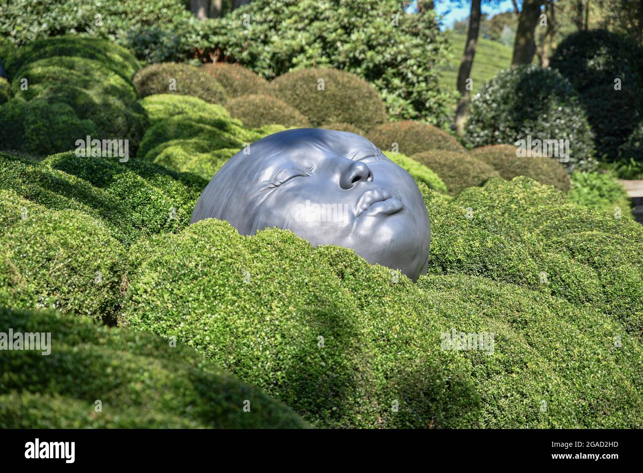 ETRETAT, FRANCE - SEPTEMBER 02, 2018: Giant rubber heads sleeping on green pillows. Boxwood garden in the famous garden of Etretat, Normandy Stock Photo