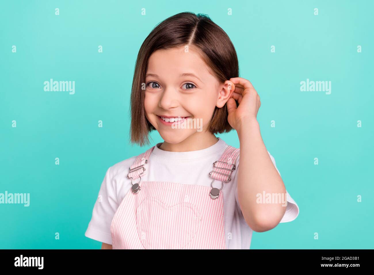 Photo of cute adorable school girl wear pink overall smiling arm hair isolated teal color background Stock Photo