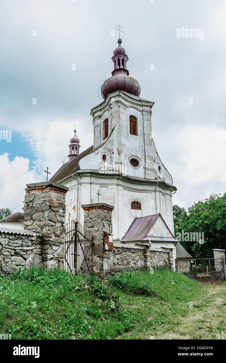 Puste Zibridovice,Czech Republic - July 12,2021. White old baroque Church of Saint Mary Magdalene with bell tower and cemetery in small Czech village Stock Photo