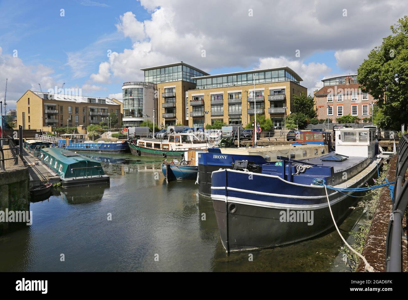 Houseboats and barges moored at a redeveloped Dock on the River Thames at Brentford, west London, UK. New cafes and apartments in background. Stock Photo