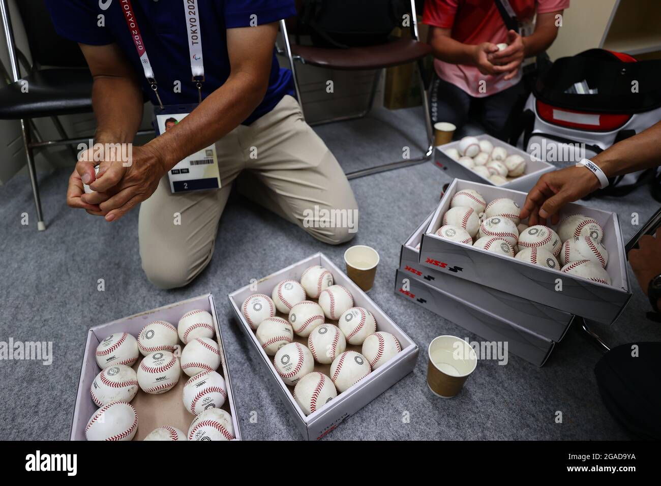 Umpiring officials rub baseballs with mud prior to a game during the Tokyo 2020 Olympics at the Yokohama Baseball Stadium in Yokohama, Japan July 30, 2021. REUTERS/Jorge Silva Stock Photo