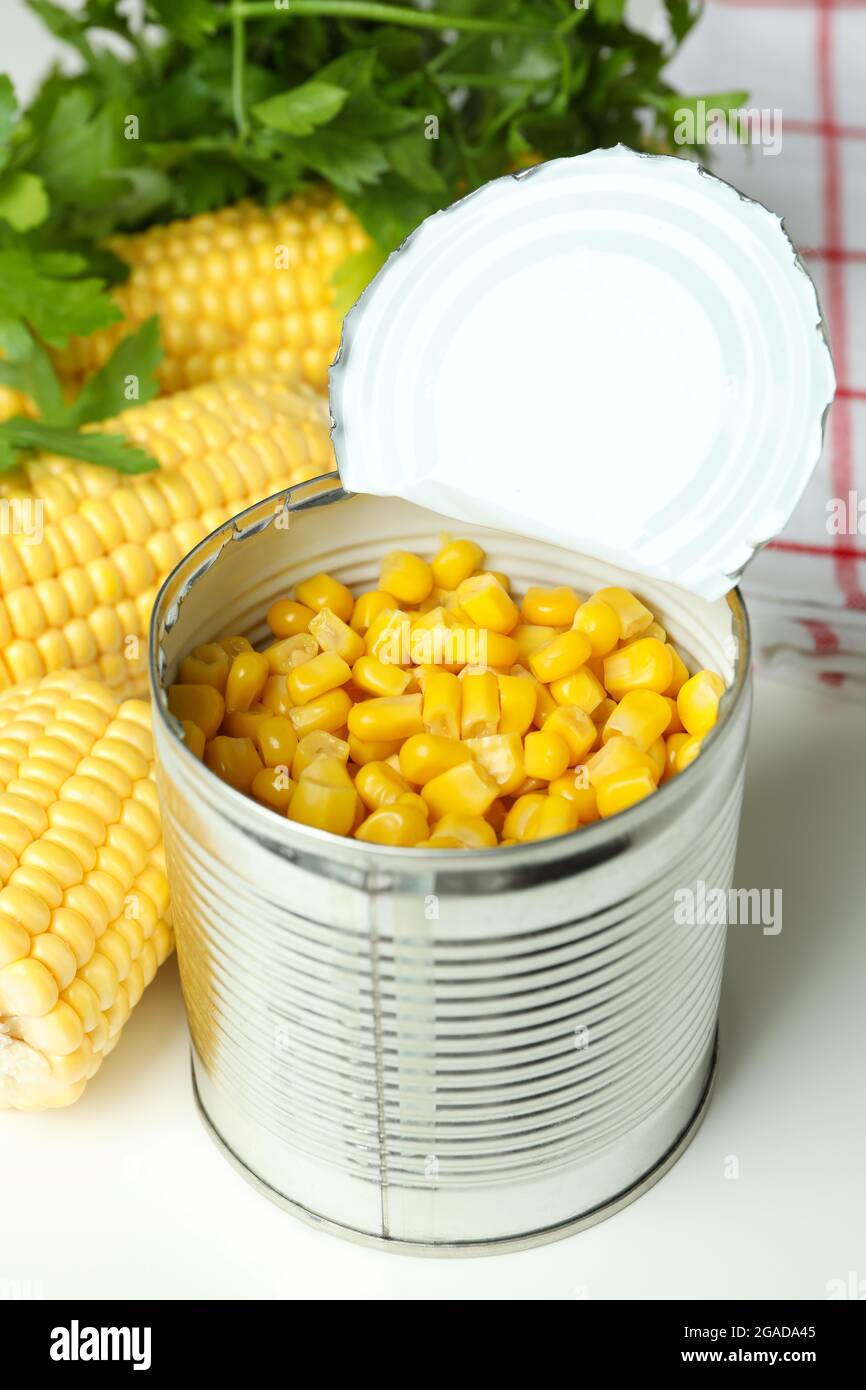 Raw corn and canned corn on white table Stock Photo