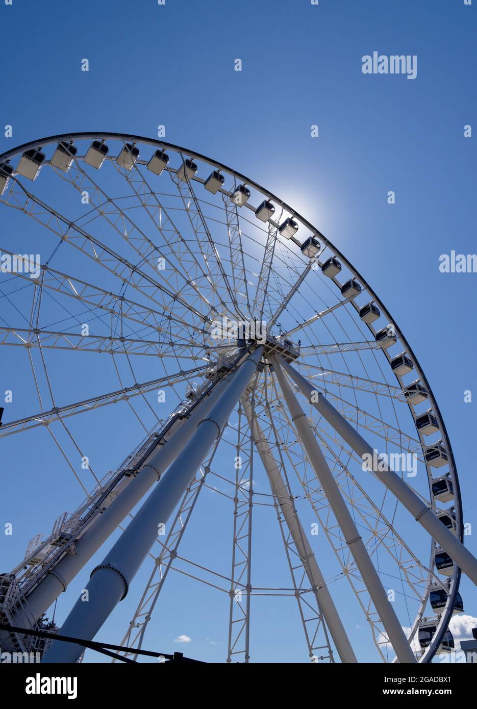 Looking up at the Grande Roue big wheel in the Montreal Old Port (Vieux Port) with the sun shining behind Stock Photo