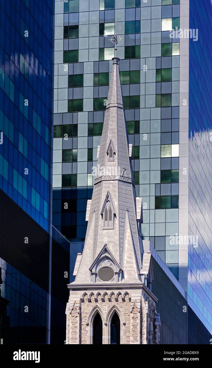 The spire of an old church incorporated into modern architecture in the new CHUM hospital building on St Denis, Montreal, Quebec Stock Photo