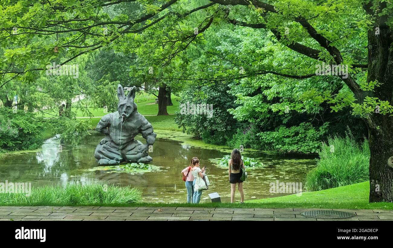 a group of Visiters by Thomas Schütte 'Hare' sculpture at Fondation Beyeler, green park  area. Stock Photo