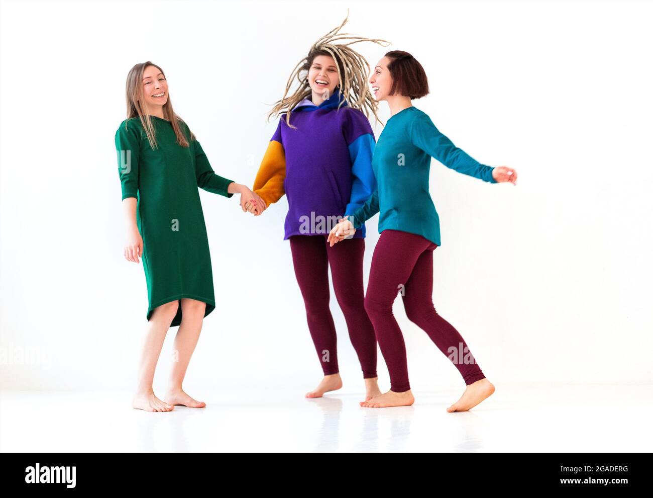Image Of Three Happy Playful Barefoot Women Of Different Age Holding
