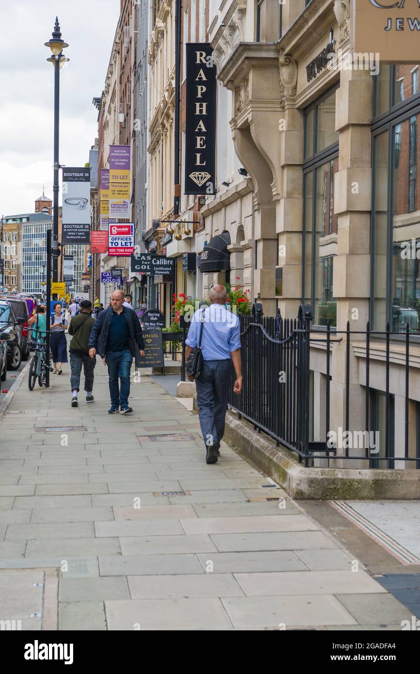 Street scene. People out and about in Hatton Garden pass by jewellery shops, London, England, UK