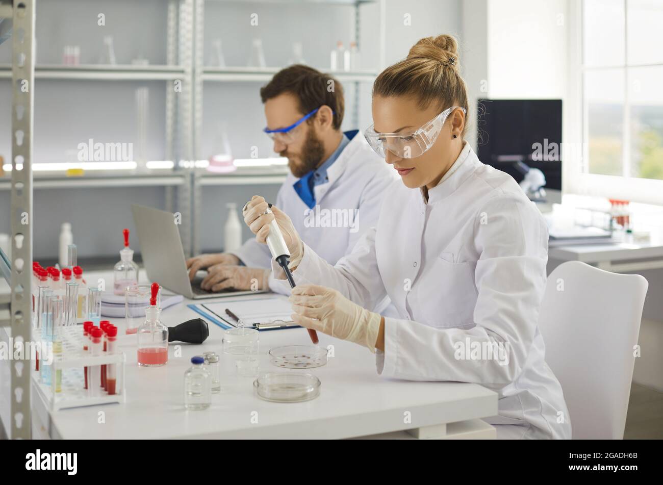 Young female scientist making research in lab analyzing new virus in blood Stock Photo