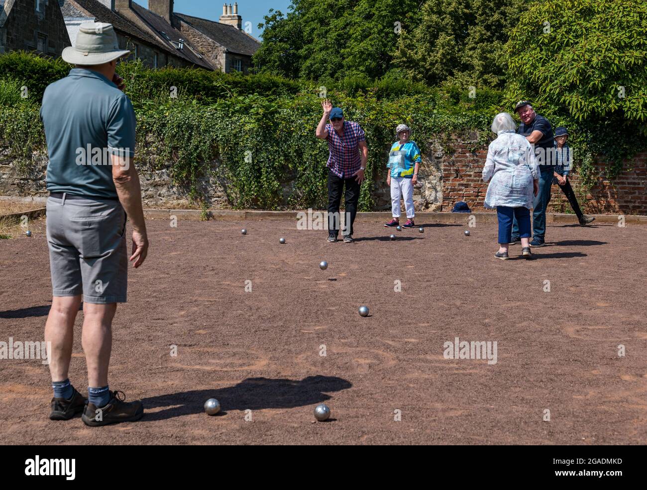 Senior citizens, older people or pensioners playing petanque or boules in Summer sunshine, Haddington, East Lothian, Scotland, UK Stock Photo