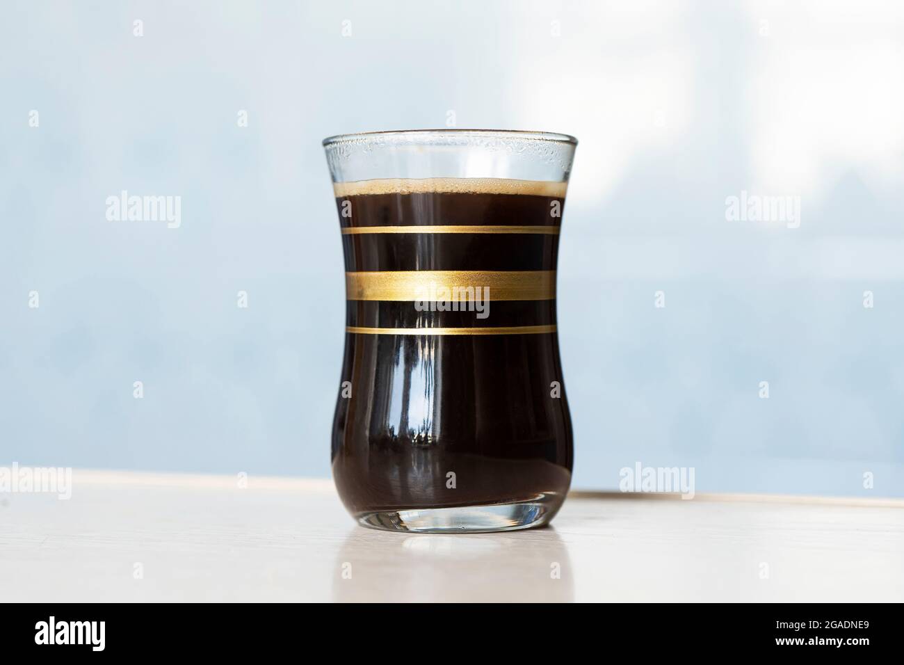 black coffee in glass cup on blue background Stock Photo