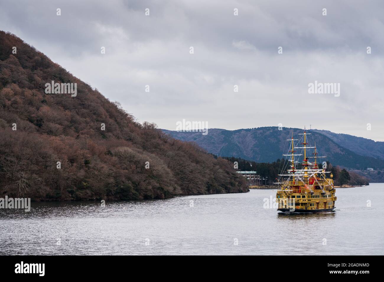Lake Ashiko in Japan. A yellow pirate ship sails along the coastline of Fuji Hakone Izu National Park Stock Photo
