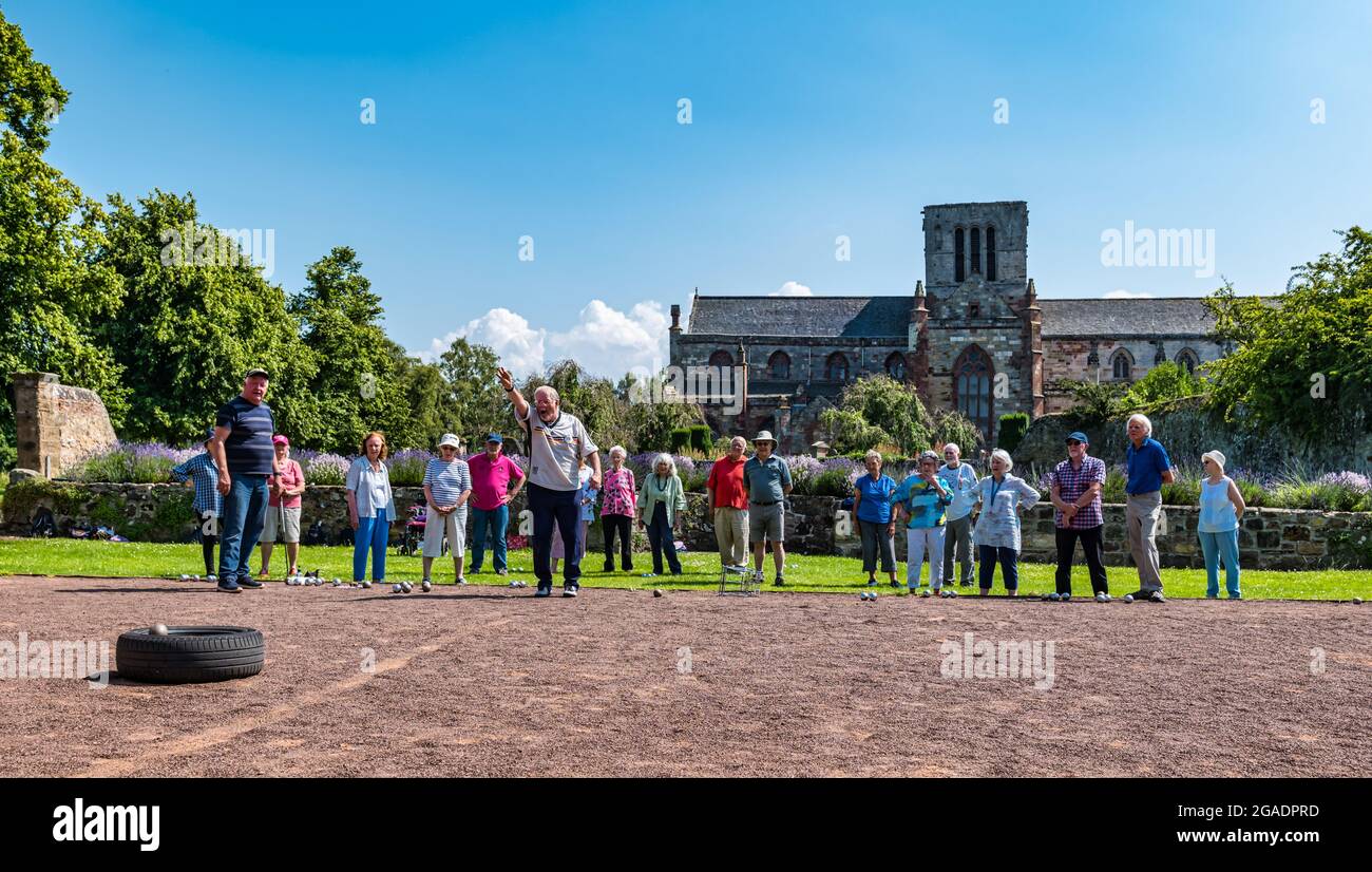 Older people or pensioners having coaching lesson playing petanque or boules in Summer sunshine, Haddington, East Lothian, Scotland, UK Stock Photo