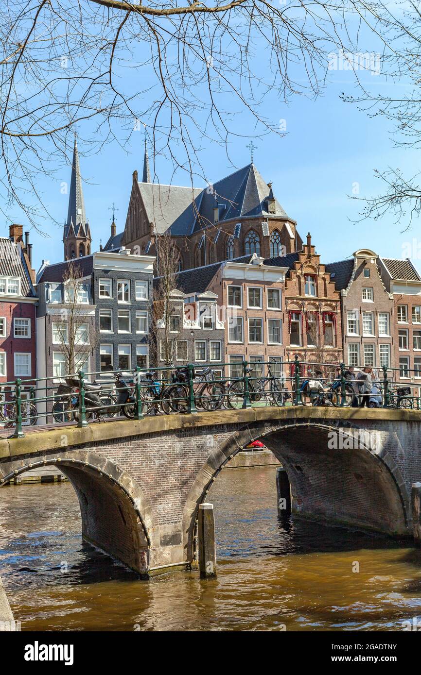 Gabled houses and De Krijtberg Kerk behind Herengracht arched bridge, viewed from Leidsegracht, Amsterdam, Holland Stock Photo