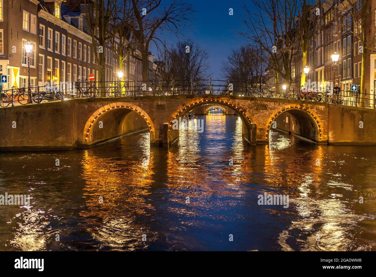 Bridge with arches, illuminated at night, Herengracht and Leidsegracht canals, Amsterdam Stock Photo