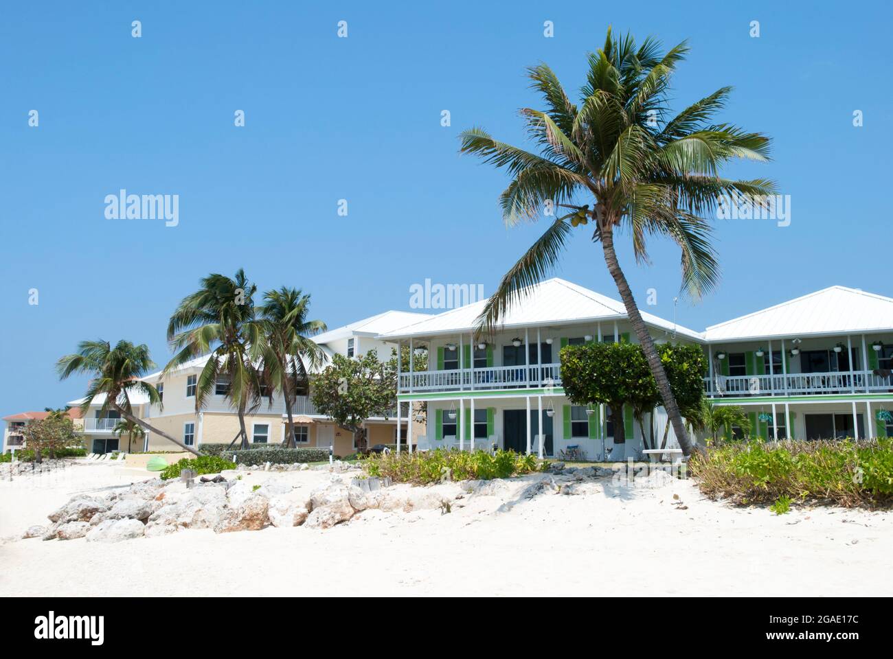 Houses and leaning palm trees on Grand Cayman island Seven Mile Beach ...