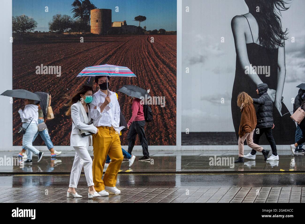 London, UK. 30 July 2021. UK Weather - People in Oxford Street experience windy and rainy conditions as Storm Evert passes across the capital. Yellow warnings for wind and thunderstorms are in place across the east and south-east of England.  Credit: Stephen Chung / Alamy Live News Stock Photo