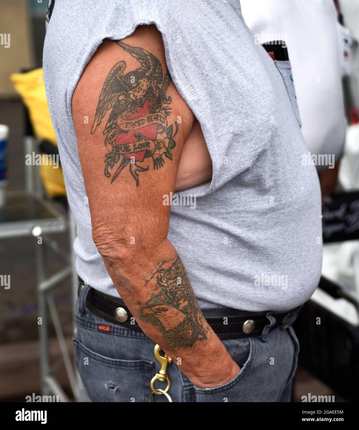 A man with tattoos on his arm visits an outdoor art show in Santa Fe, New Mexico. Stock Photo