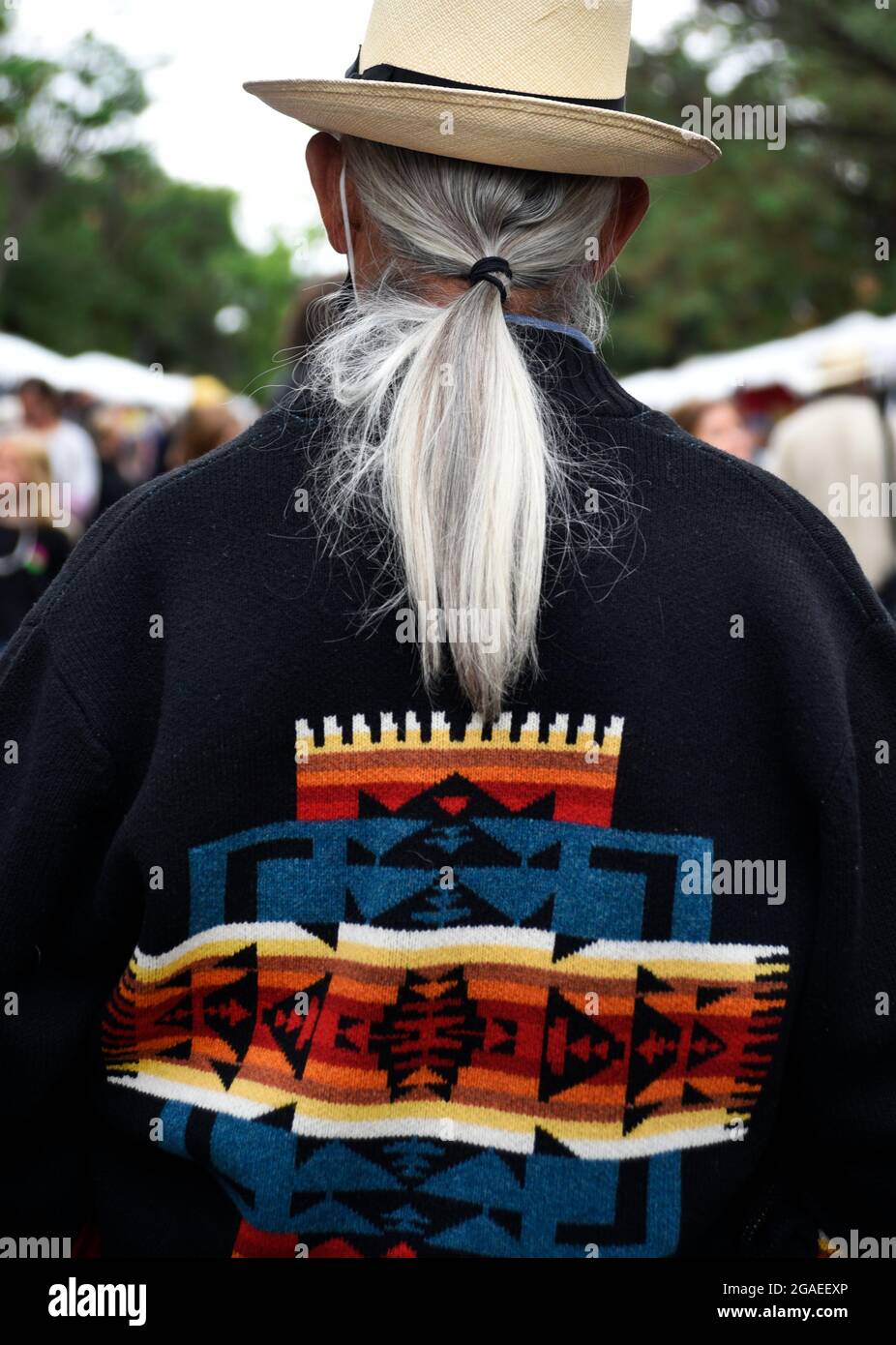 A senior man with lone gray and white hair enjoys an outdoor art festival in Santa Fe, New Mexico. Stock Photo
