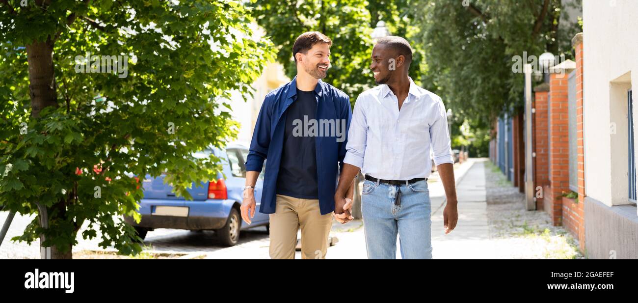 Gay Couple Dating In Jeans. Walking On Street In City Stock Photo