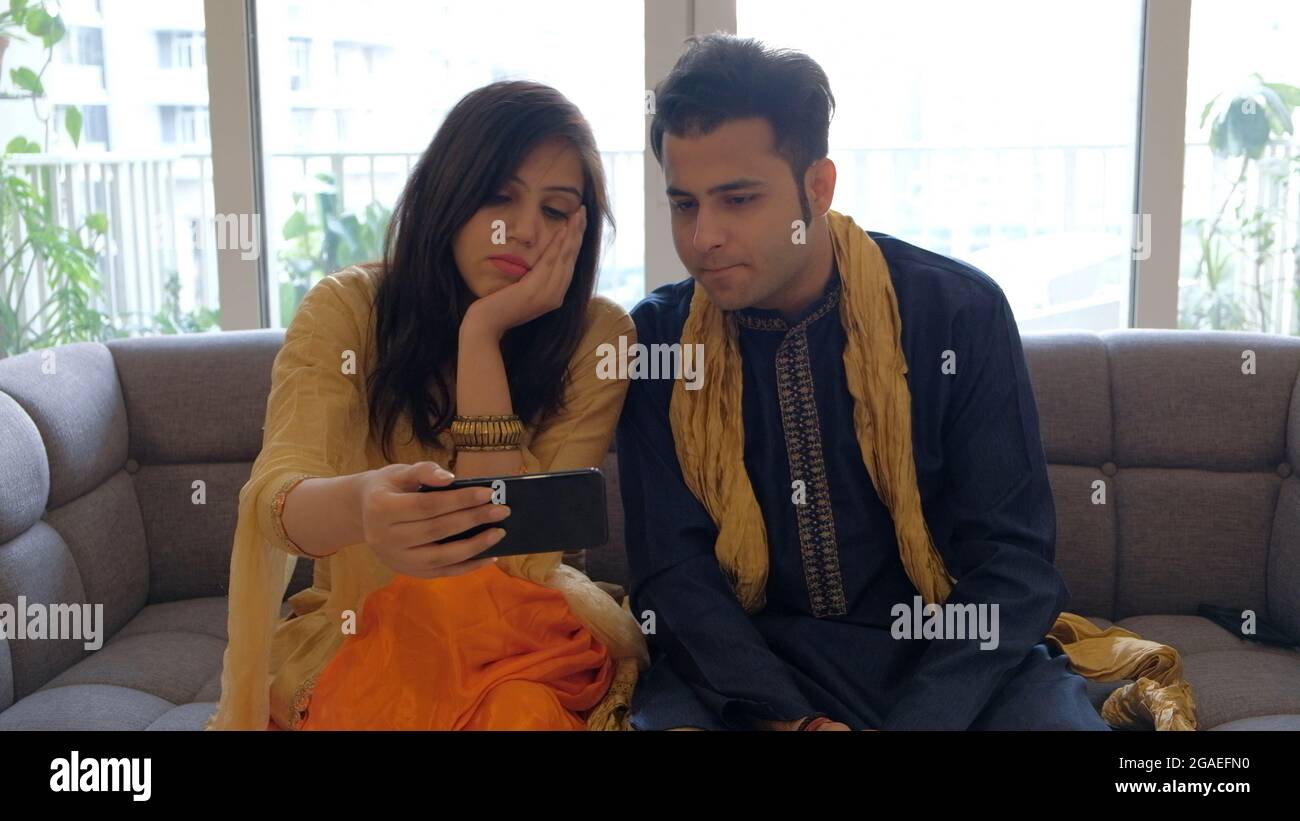 Young Indian couple spending time together in a living room Stock Photo ...
