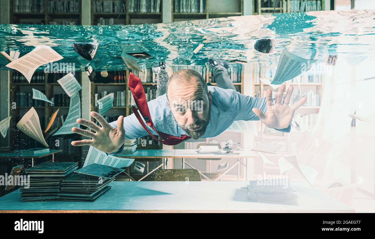 businessman swimming in a flooded office Stock Photo