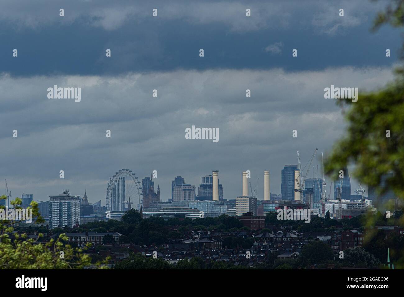 London, UK. 30 July 2021. The London Eye and Battersea chimneys  is shrouded  under storm clouds with unpredictable weather of sunshine showers and gale force winds from Storm Evert in London and southern parts of England. Credit amer ghazzal/Alamy Live News. Stock Photo