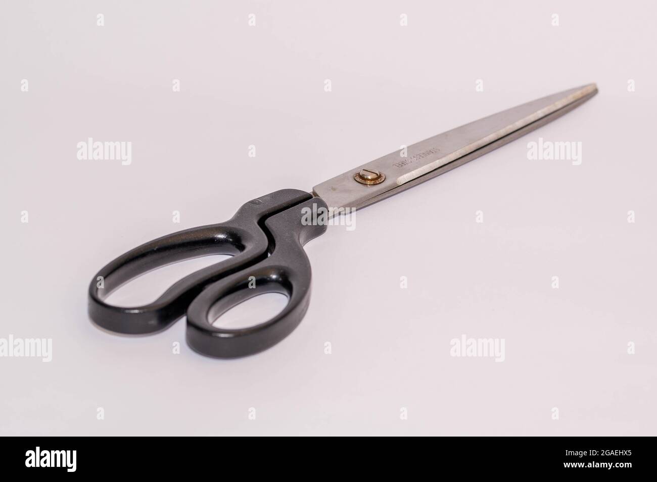 large pair of used wall paper scissors on a white background Stock Photo