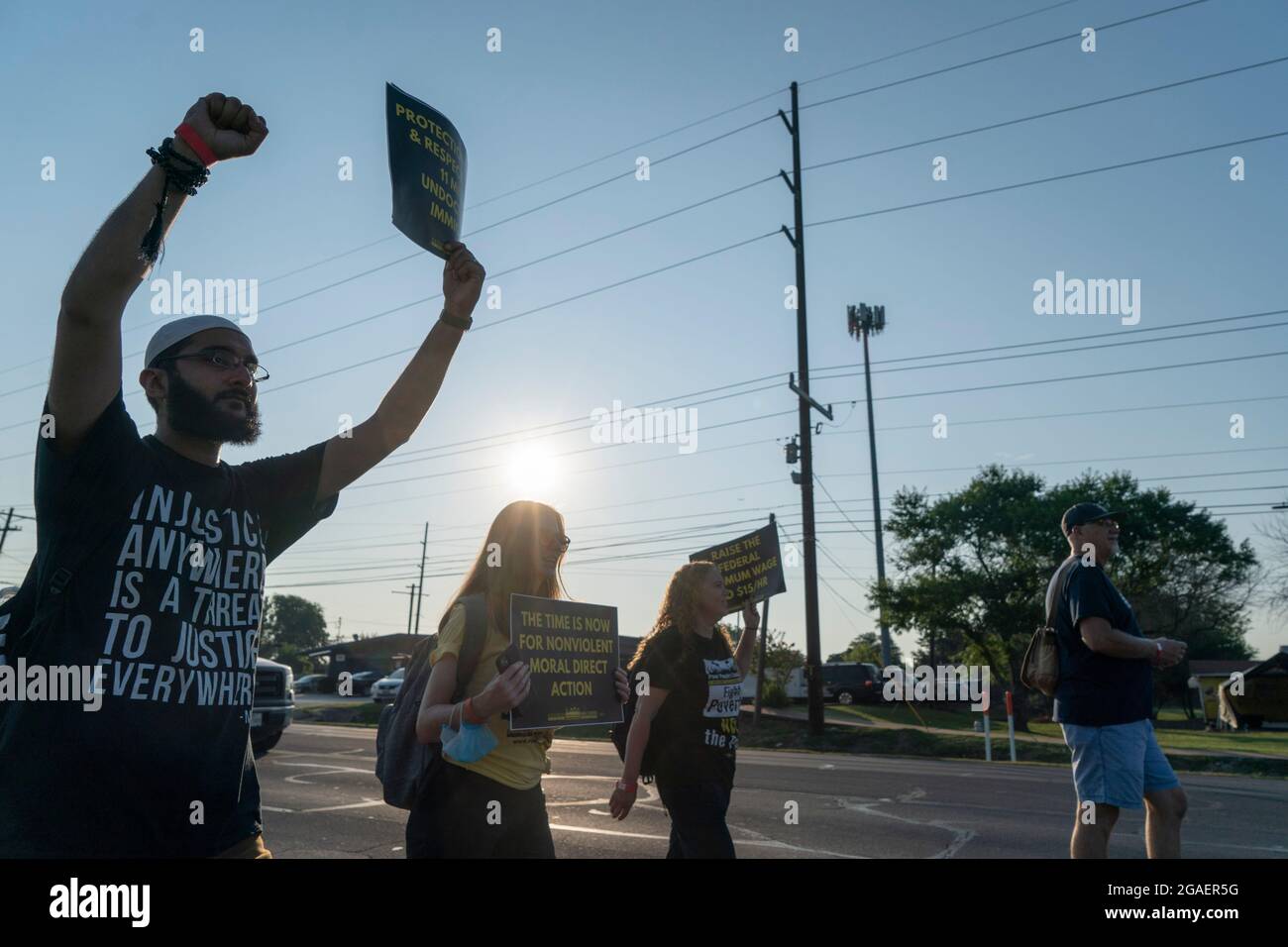 Austin, Texas USA, July 30, 2021: Voting rights activists march along an interstate highway frontage road toward the Texas Capitol from north Austin on the third day of a 30-mile journey protesting Republican efforts to suppress votes nationwide and in Texas. Shifts of marchers trade off in an effort to combat oppressive Texas heat. Credit: Bob Daemmrich/Alamy Live News Stock Photo