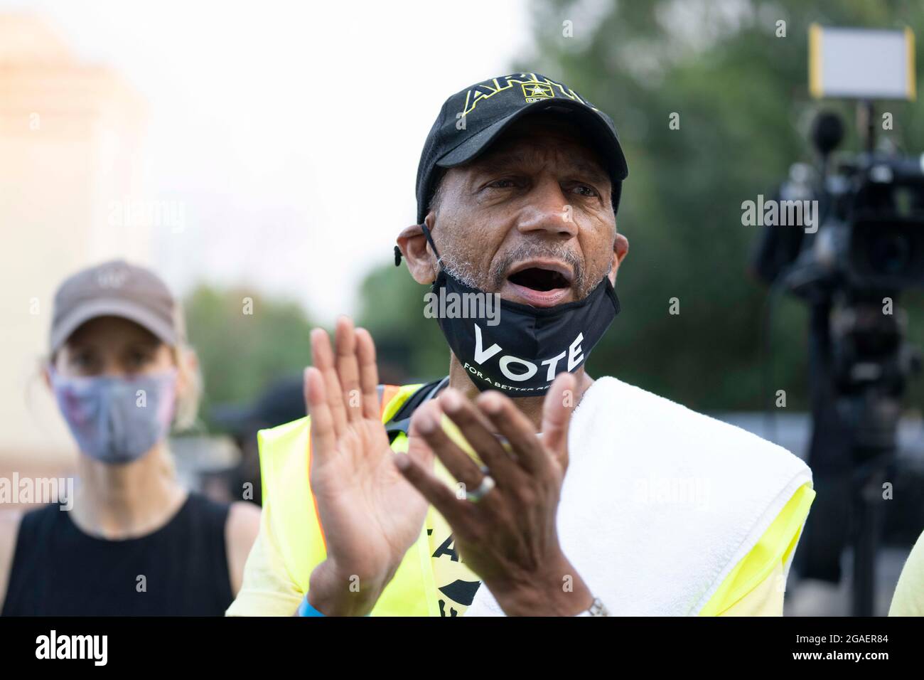 Rev. DARRELL GRAY of St. Louis claps at the start as voting rights groups march toward the Texas Capitol from north Austin on the third day of a 30-mile journey protesting Republican efforts to suppress votes nationwide and in Texas. Shifts of marchers trade off in an effort to combat oppressive Texas heat. Credit: Bob Daemmrich/Alamy Live News Stock Photo