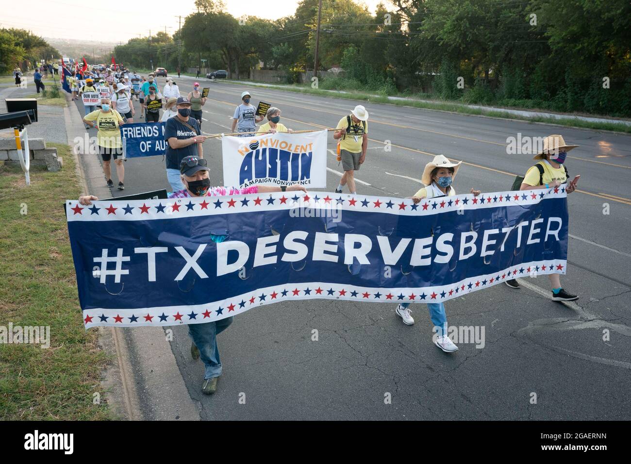 Austin, Texas USA, July 30, 2021: Voting rights groups march along an interstate highway frontage road toward the Texas Capitol from north Austin on the third day of a 30-mile journey protesting Republican efforts to suppress votes nationwide and in Texas. Shifts of marchers trade off in an effort to combat oppressive Texas heat. Credit: Bob Daemmrich/Alamy Live News Stock Photo