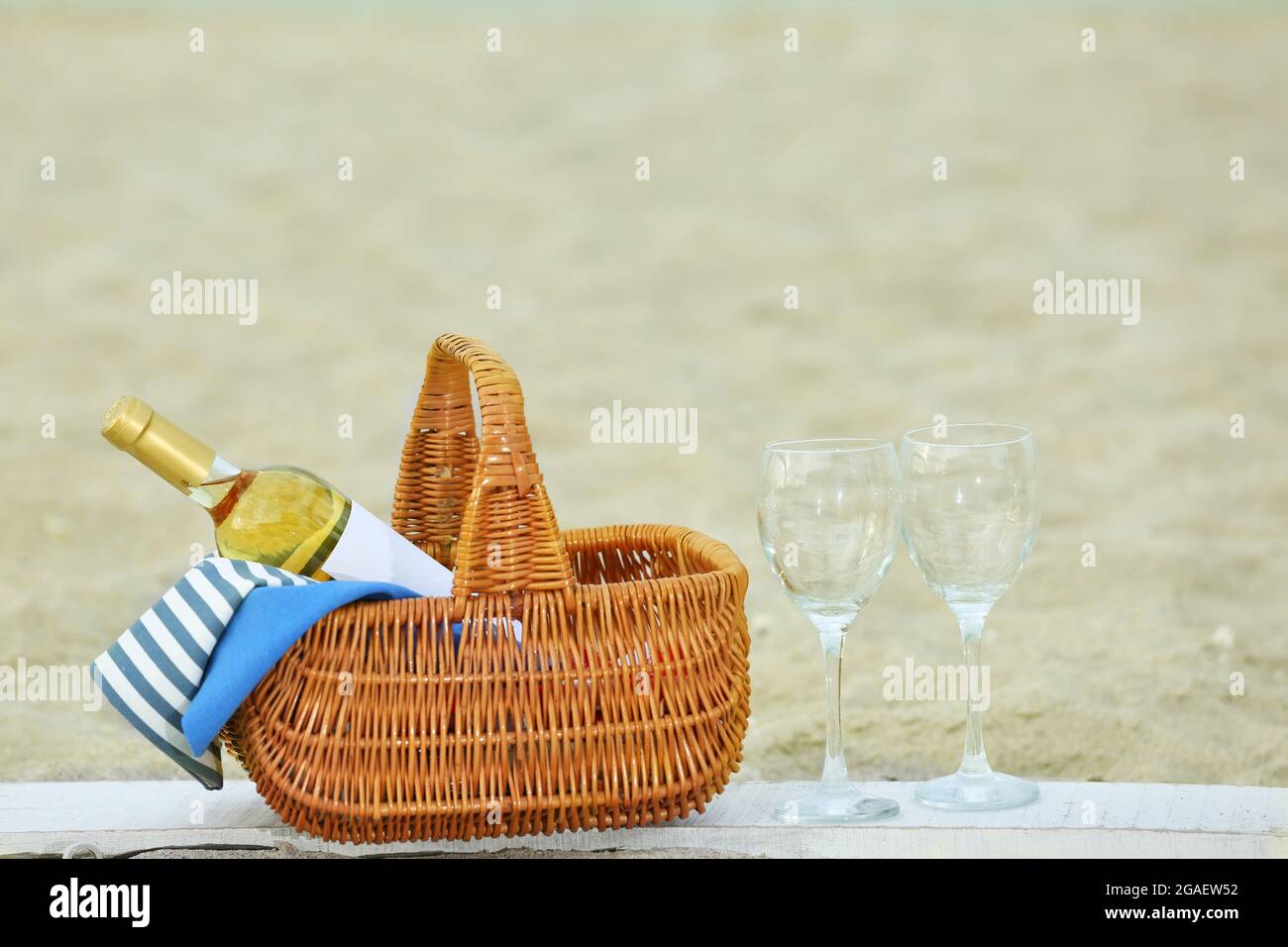 Picnic basket with bottle of wine on sand beach Stock Photo - Alamy