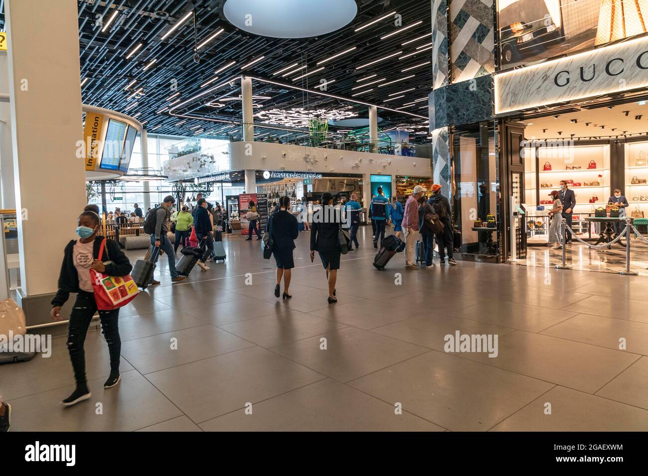 Amsterdam, New York, The Netherlands. 29th July, 2021. Amsterdam, the Netherlands - July 29, 2021: Travelers walk through Shiphol airport. Fully vaccinated travelers are allowed to travel during pandemic but required to wear masks at airports and while on aircrafts. (Credit Image: © Lev Radin/ZUMA Press Wire) Stock Photo