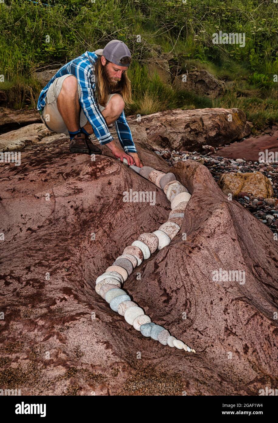 Jon Foreman, land artist, creates a spiral rcok or stone sculpture on