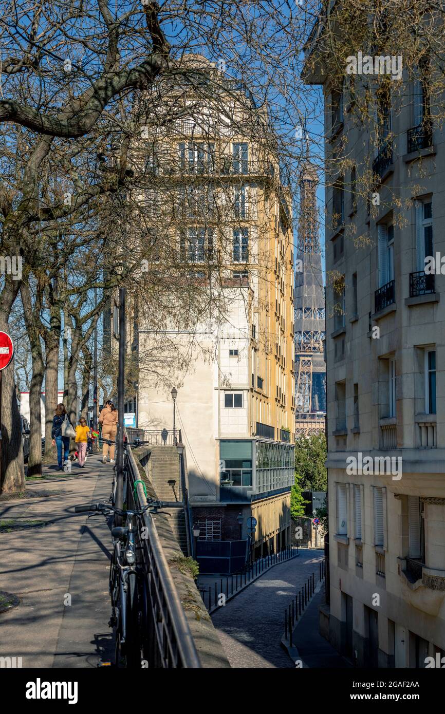 Paris, France - March 30, 2021: Iconic Eiffel tower viewed from parisian street between 2 buildings in Paris Stock Photo