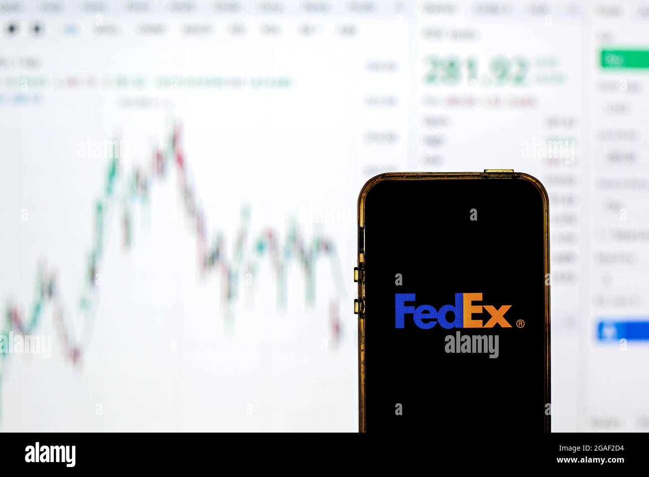In this photo illustration a FedEx Corporation logo seen displayed on a smartphone with the stock market information of FedEx Corporation in the backg Stock Photo