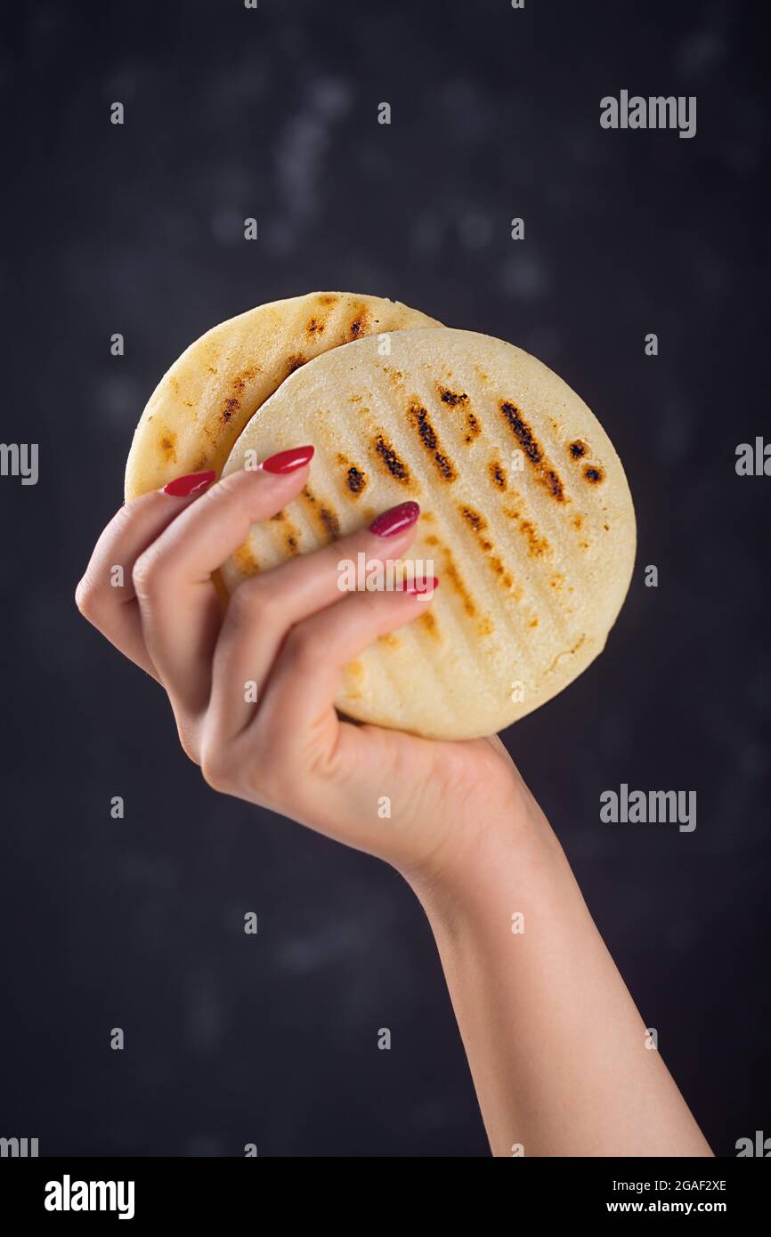 Woman holds arepa is a type of meal made from cornmeal, traditional in ...