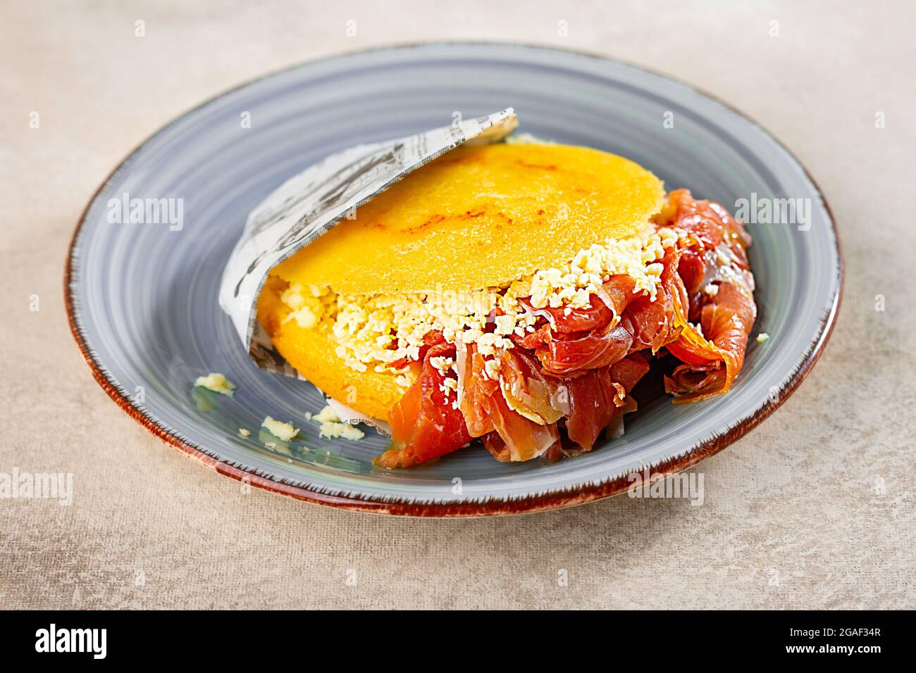 https://c8.alamy.com/comp/2GAF34R/stuffed-arepa-on-a-plate-prepared-from-cornmeal-traditional-cuisine-of-colombia-and-venezuela-2GAF34R.jpg