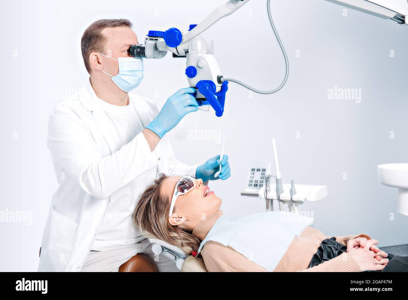 Pretty caucasian woman in dentist chair in modern dental clinic. Doctor