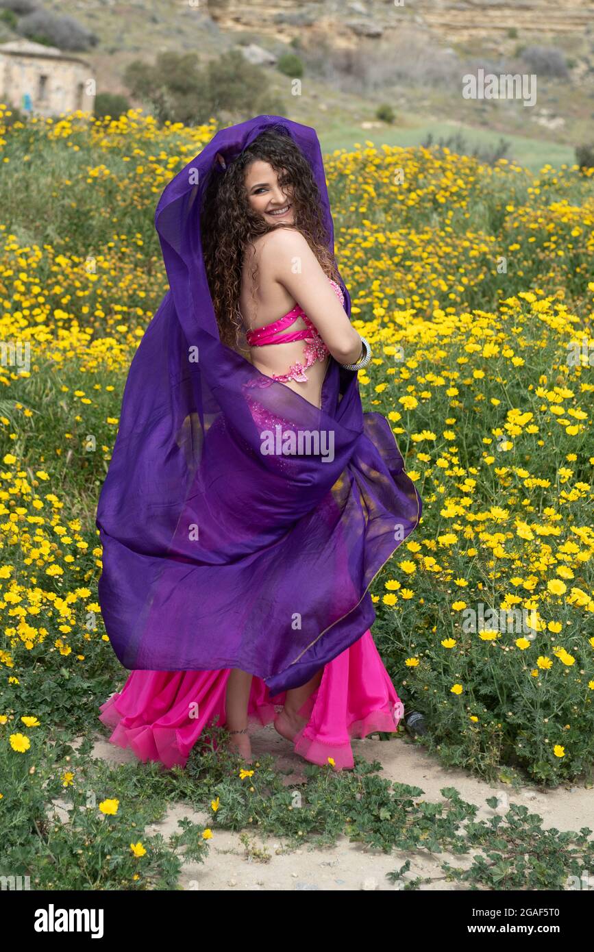 Woman performing belly oriental dancing wearing coloured costume. Outdoors dancing Stock Photo