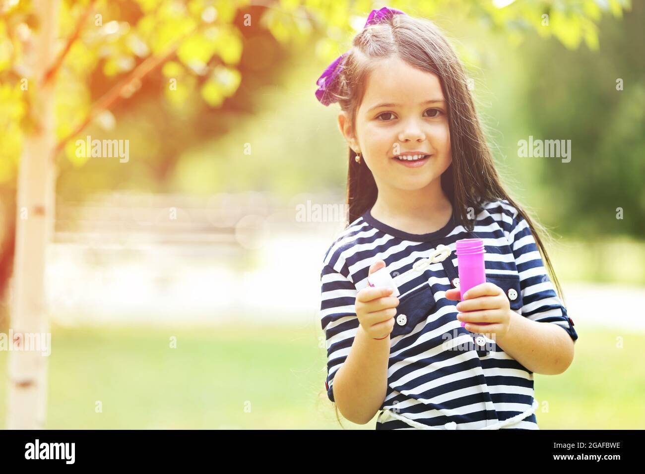Happy little girl with bubbles in the park Stock Photo - Alamy
