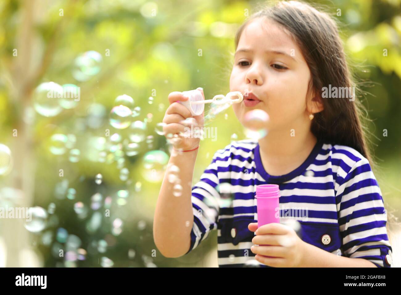 Happy little girl with bubbles in the park Stock Photo Alamy