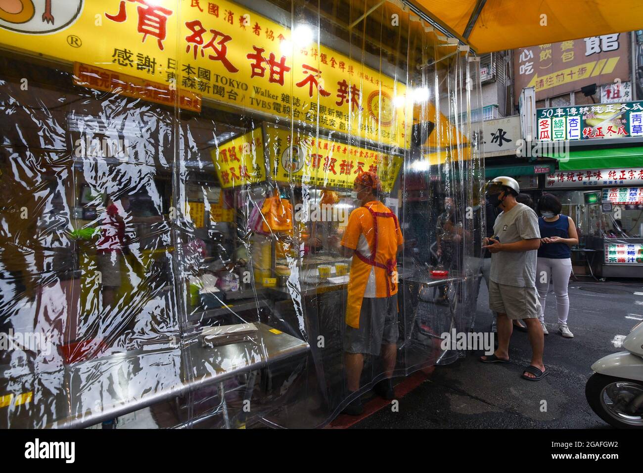 Taipei, Taiwan. 30th July, 2021. People are lining up to take out food in Wanhua Night Market amid covid-19 pandemic.As the number of confirmed coronavirus cases has continued to dip lately, Central Epidemic Command Center (CECC) said that the CECC is planning to draw up epidemic management guidance for restaurants and night markets that would allow them to reopen. (Credit Image: © Shih Hsun Chao/SOPA Images via ZUMA Press Wire) Stock Photo