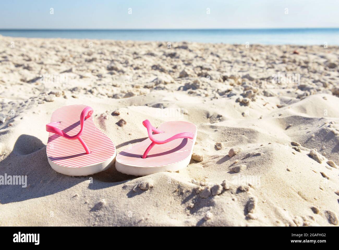 Flip flops on beach sand closeup Stock Photo - Alamy