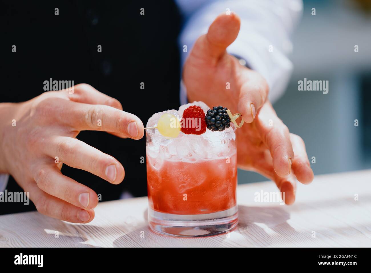 Bartender making a fruity cocktail Stock Photo