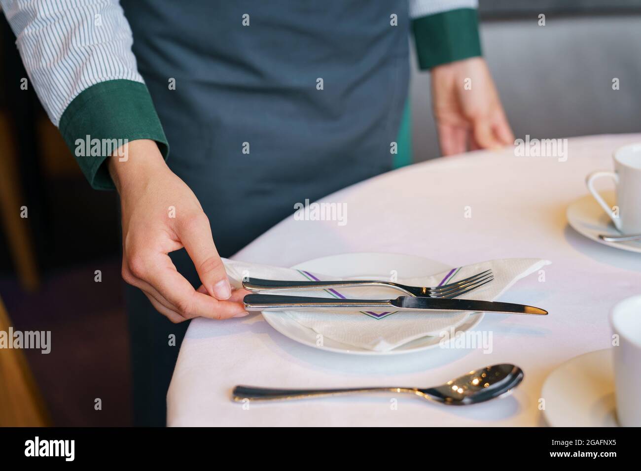 Waiting staff prepare a table in a restaurant Stock Photo Alamy