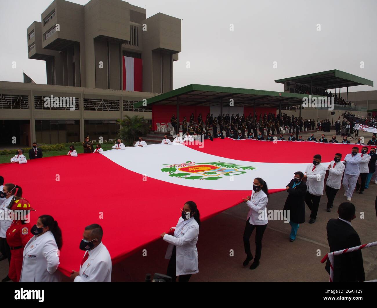 Lima, Peru. 30th July, 2021. Medical personnel of the Peruvian armed forces carrying a gigantic flag participating on military parade commemorating 200th anniversary of Peruvian independence. Credit: Fotoholica Press Agency/Alamy Live News Stock Photo