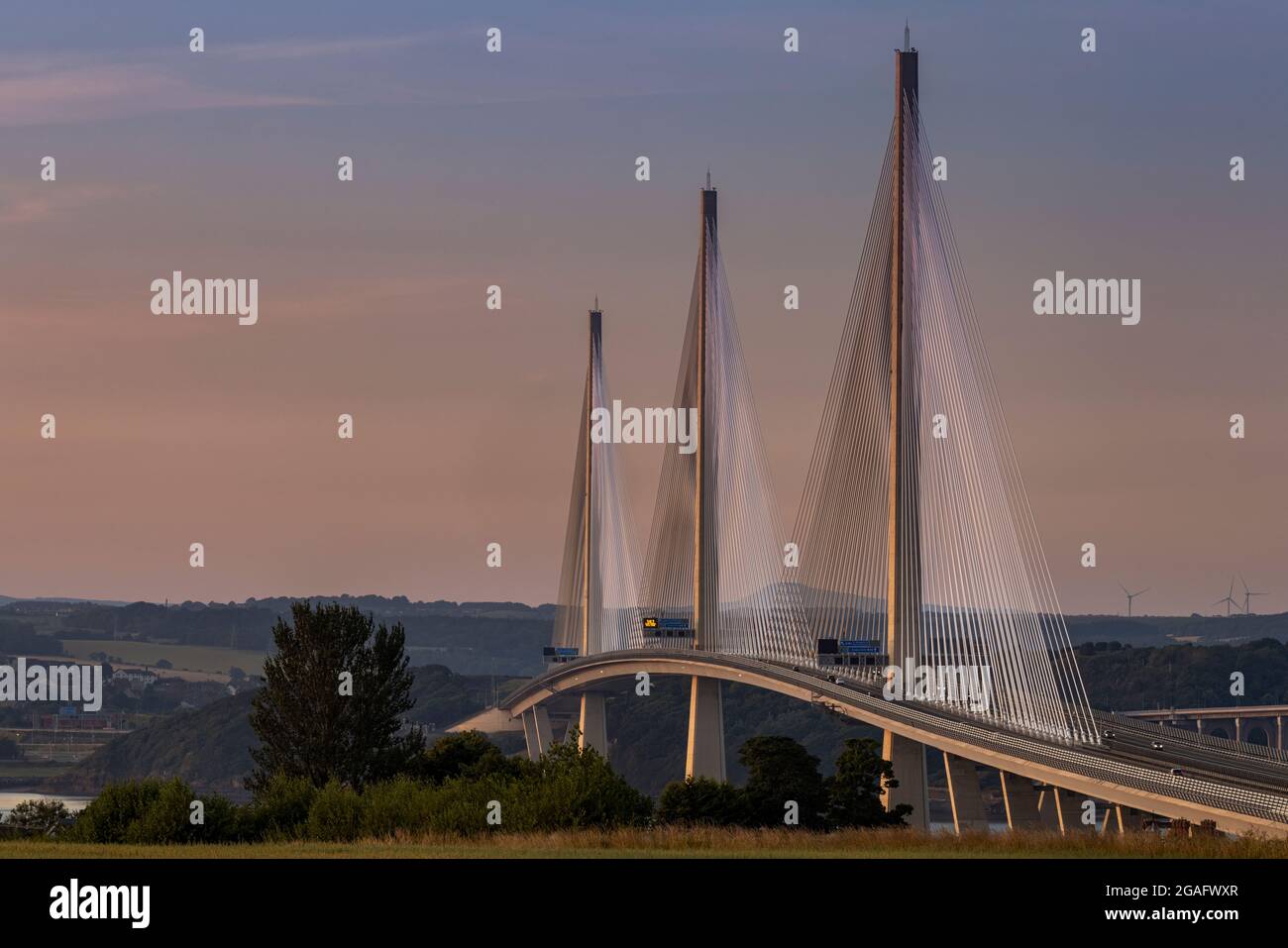 The Queensferry Crossing captured at sunset as the light from the sunset lights up the bridge Stock Photo